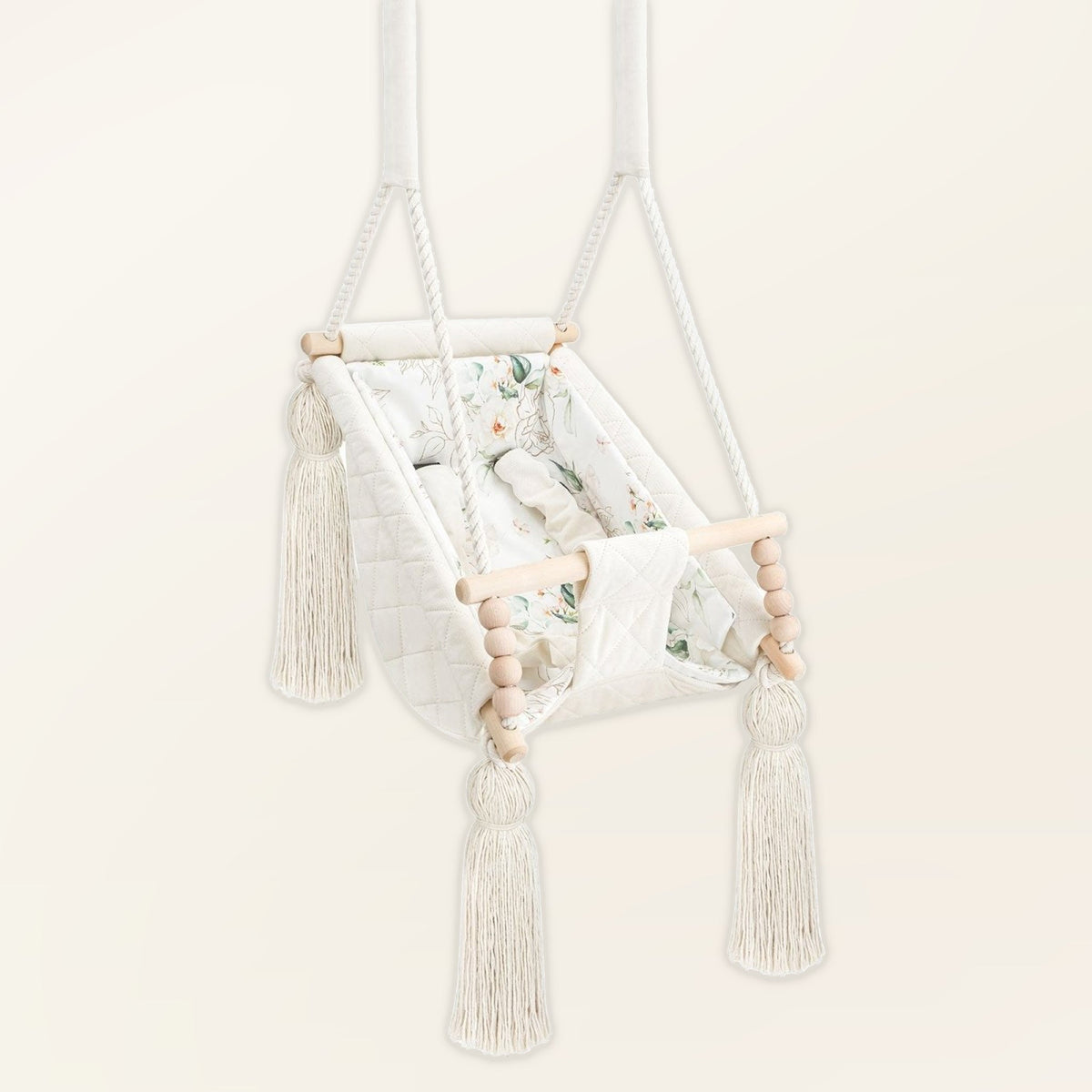 Amaca altalena per bebè in velluto Beige, in velluto, vista di tre quarti con nappe, perle di legno e seduta imbottita