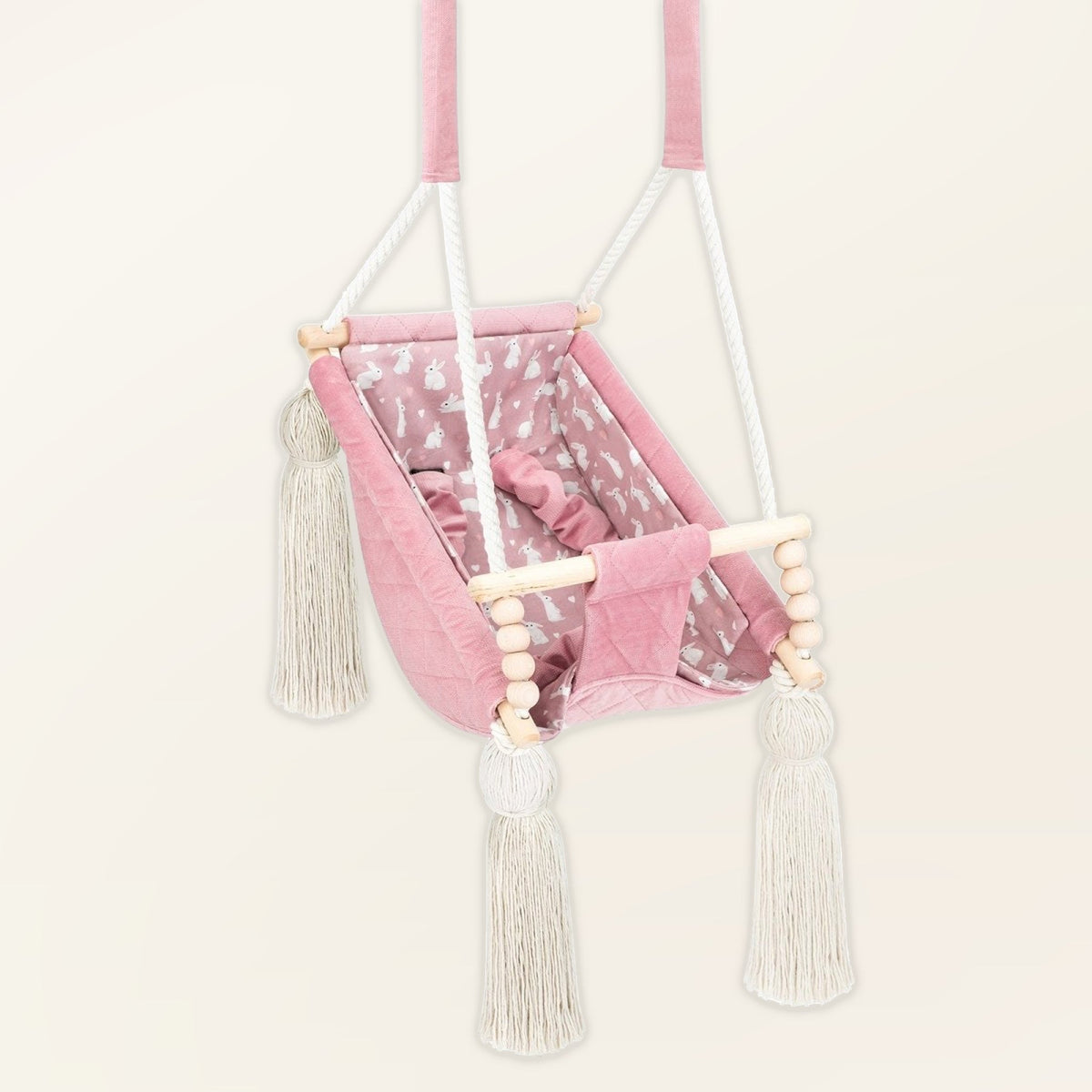 Amaca altalena per bebè in velluto Rosa, in velluto, vista di tre quarti con nappe, perle di legno e seduta imbottita